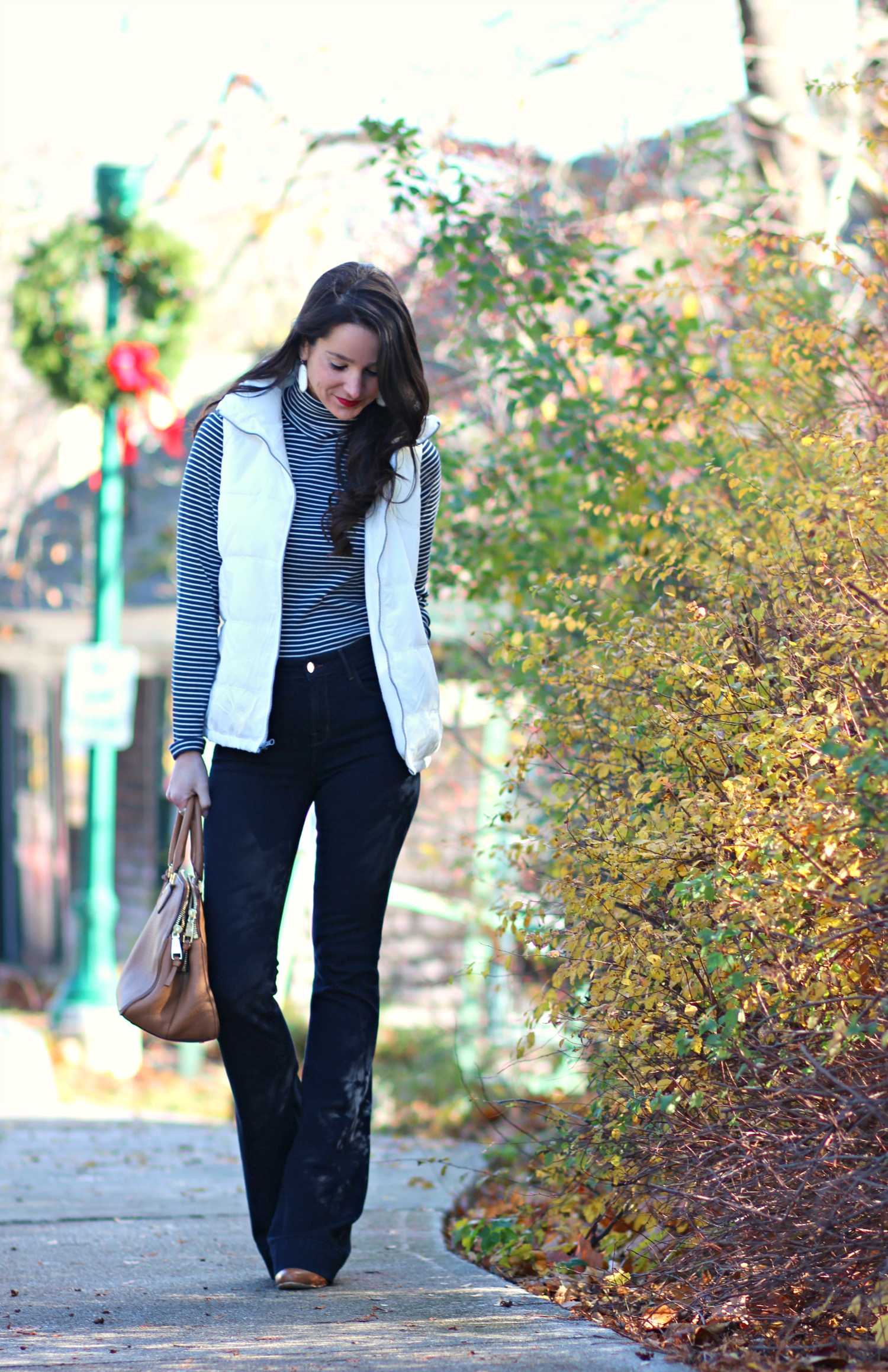 Cute and preppy fall outfit idea with J Brand dark wash flare jeans, Old Navy white puffer vest, and LL Bean striped turtleneck