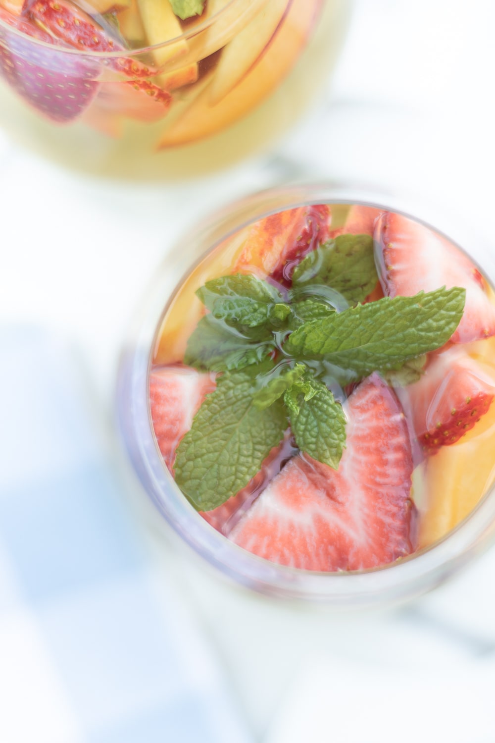 Best white sangria made with chardonnay, elderflower liqueur, strawberries, peaches, and fresh mint by blogger Stephanie Ziajka on Diary of a Debutante