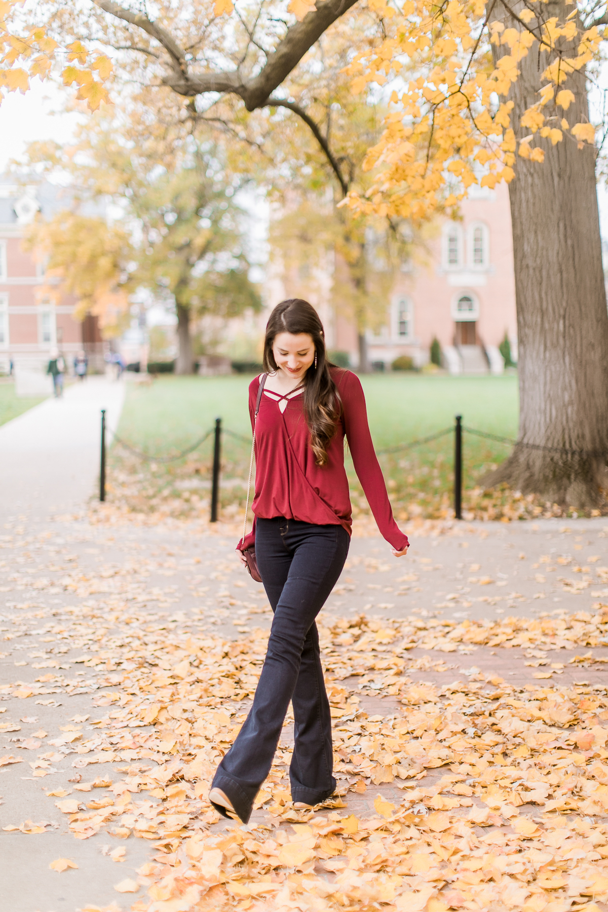 Long sleeve burgundy surplice top with dark wash flare jeans | Casual Thanksgiving outfit idea | What to Wear Out on Thanksgiving Eve by fashion blogger Stephanie Ziajka from Diary of a Debutante