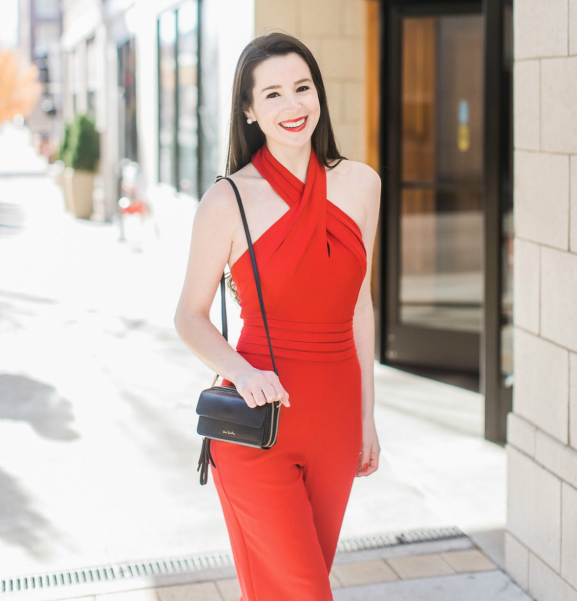 Black leather Vera Bradley RFID All in One Crossbody styled with a red wide leg jumpsuit for holiday parties by affordable fashion blogger Stephanie Ziajka on Diary of a Debutante