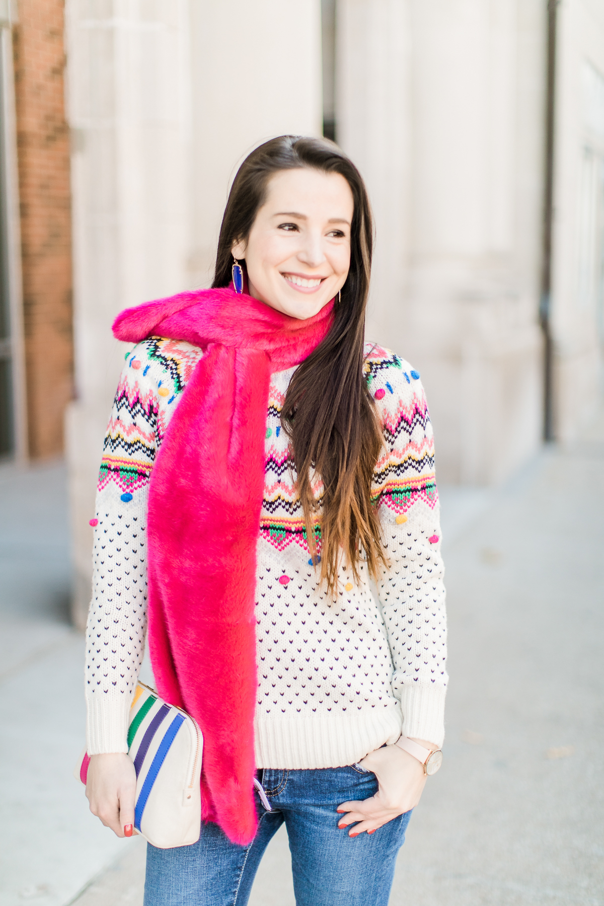Colorful Christmas sweater ideas from Talbots, featuring their Carnival Fair Isle Sweater, Pink Faux Fur Pull Through Scarf, and Canvas Stripe Makeup Pouch styled with AG the Legging ankle jeans, taupe Free People Liberty boots, and cognac Kendra Scott Skylar earrings by southern fashion blogger Stephanie Ziajka from Diary of a Debutante