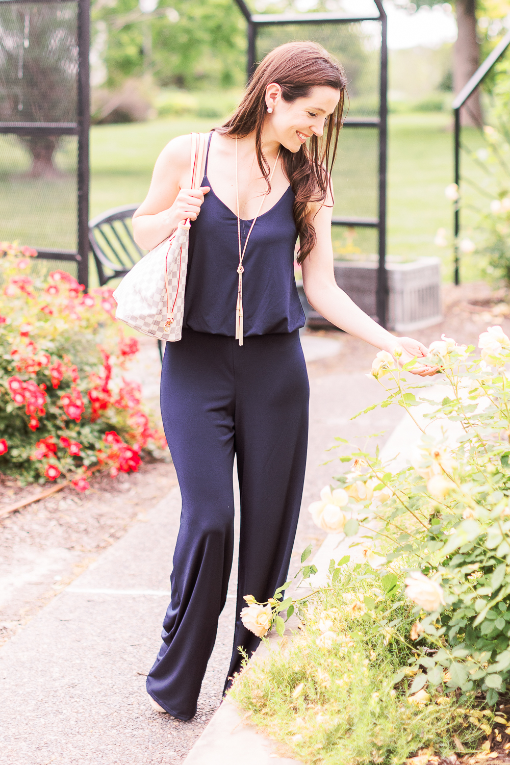 Summer Style Guide: How to Wear a Jumpsuit Casually by popular affordable fashion blogger Stephanie Ziajka from Diary of a Debutante, how to style navy jumpsuit, best shoes to wear with a jumpsuit, navy URBAN K Women's Racerback Jumpsuit, Louis Vuitton Neverfull Dupe Bag, Kendra Scott Phara Necklace