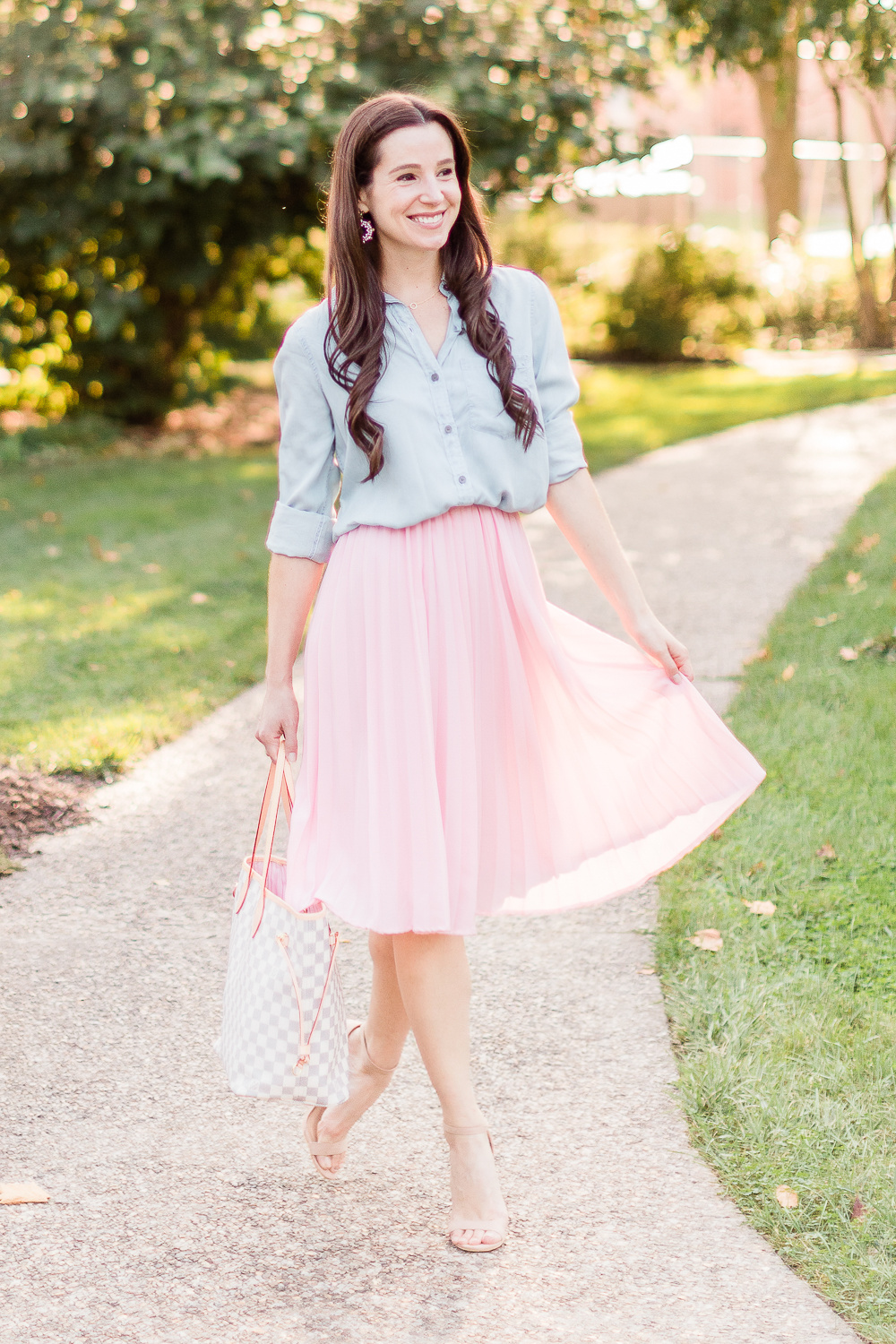 Day to Night: How to Wear a Pink Midi Skirt in the Fall by popular affordable fashion blogger Stephanie Ziajka on Diary of a Debutante, Amazon pink pleated midi skirt styled with SO chambray button down shirt, Amazon nude block heel sandals, and a Louis Vuitton Neverfull dupe bag
