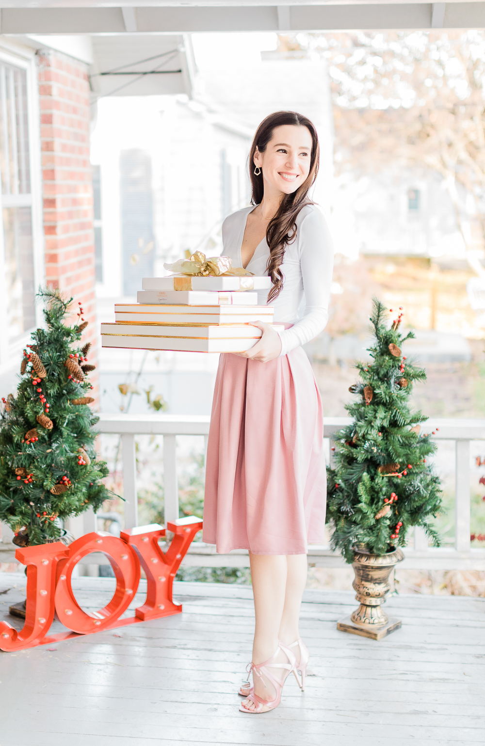 Kate Spade Inspired Holiday Outfit, girl holding gold and white presents, gold and white wrapping, Amazon pink bow skirt, preppy holiday outfit idea, pink nina dress sandals, popular affordable fashion blogger Stephanie Ziajka, popular affordable fashion blog Diary of a Debutante