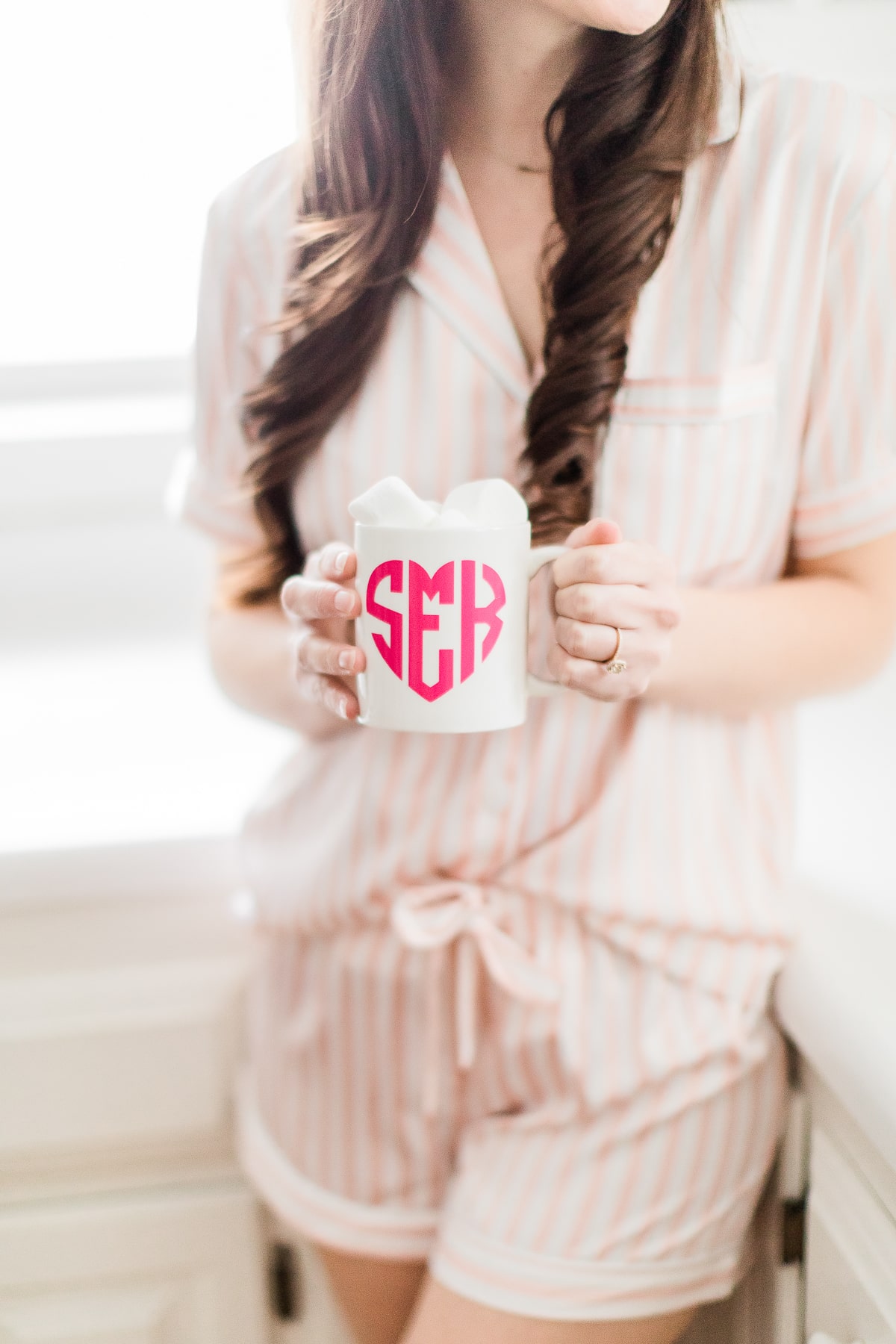 Girl in pink striped PJ set holding DIY Valentine's Day mug