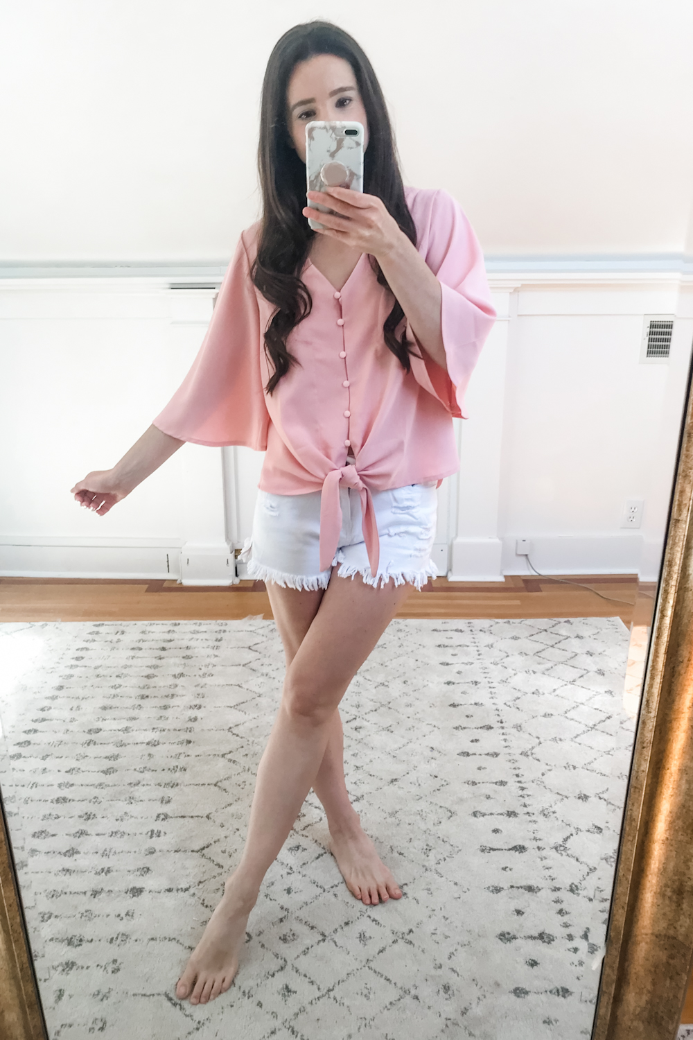 Affordable fashion blogger Stephanie Ziajka tries on a pink Amazon loose tie front top and pair of Amazon white denim shorts on Diary of a Debutante