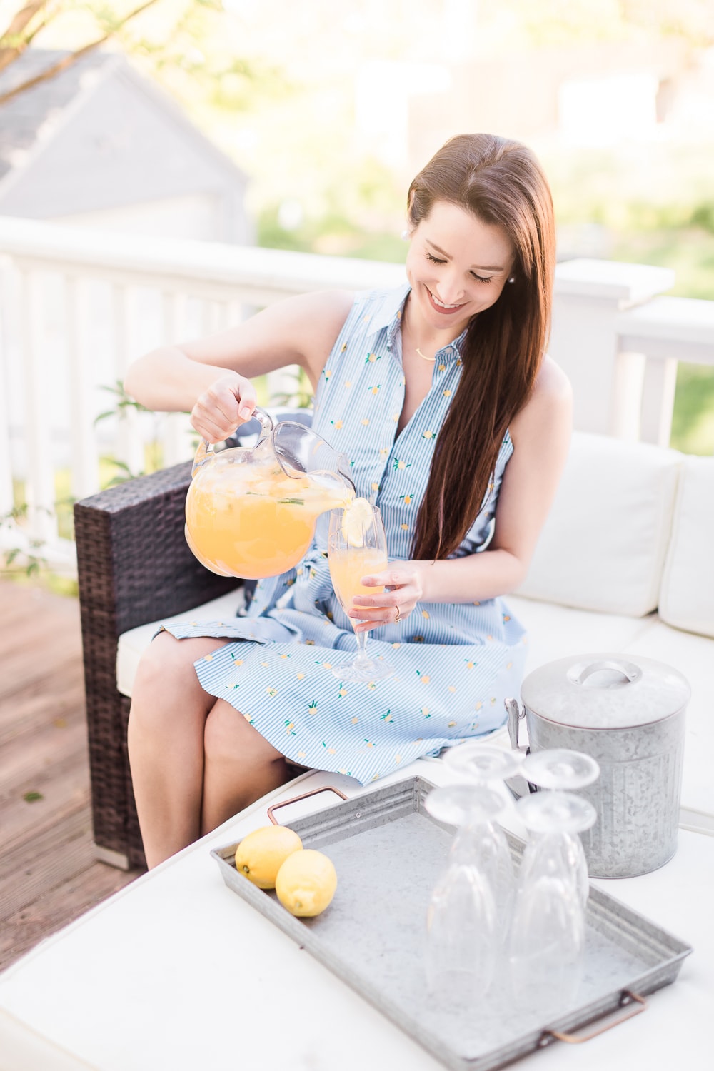 Blogger Stephanie Ziajka wearing a J.Crew Factory lemon print sleeveless shirtdress and pouring sparkling citrus punch on Diary of a Debutante