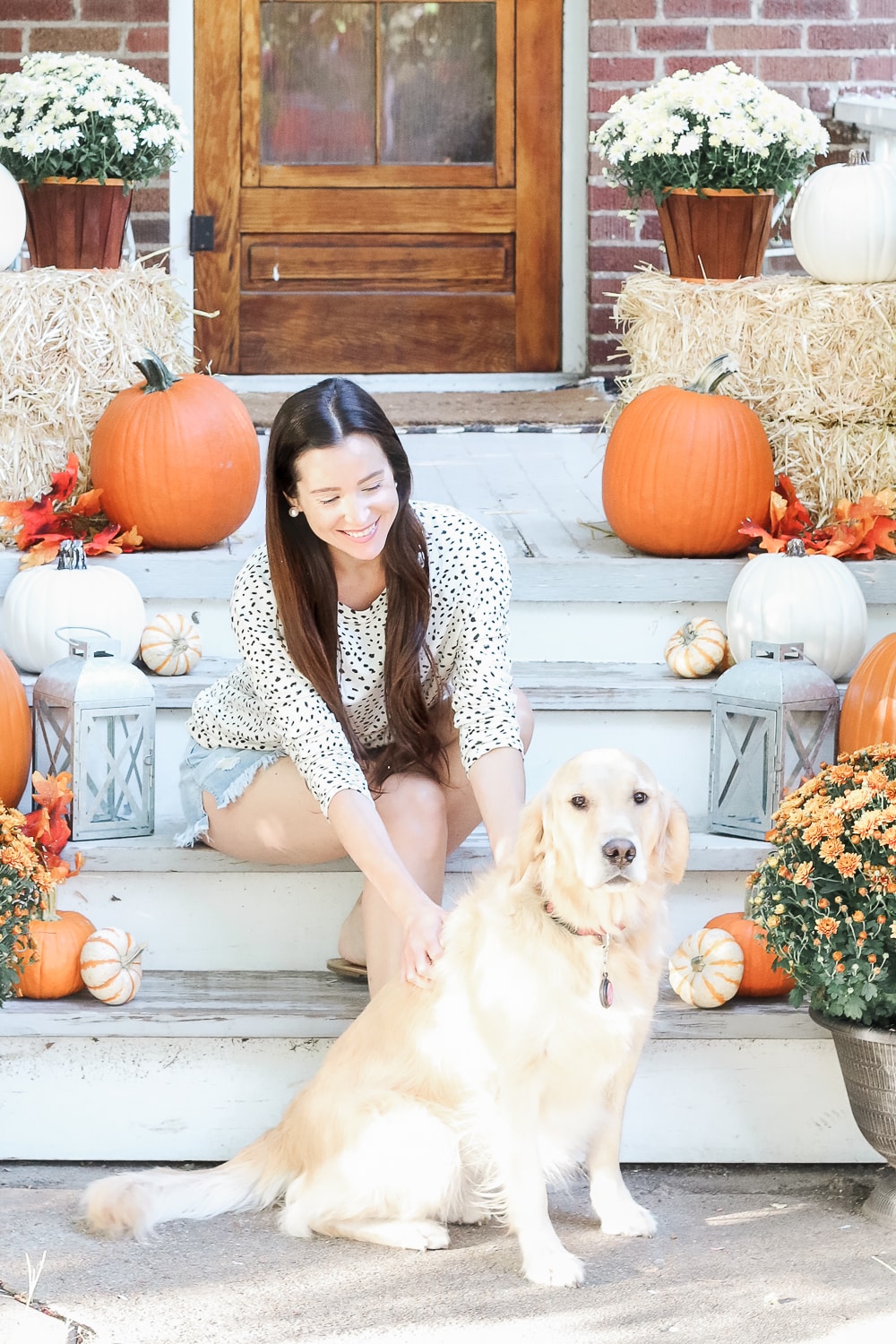 Blogger Stephanie Ziajka and her golden retriever Nala show off some affordable fall decor ideas for small porches on Diary of a Debutante