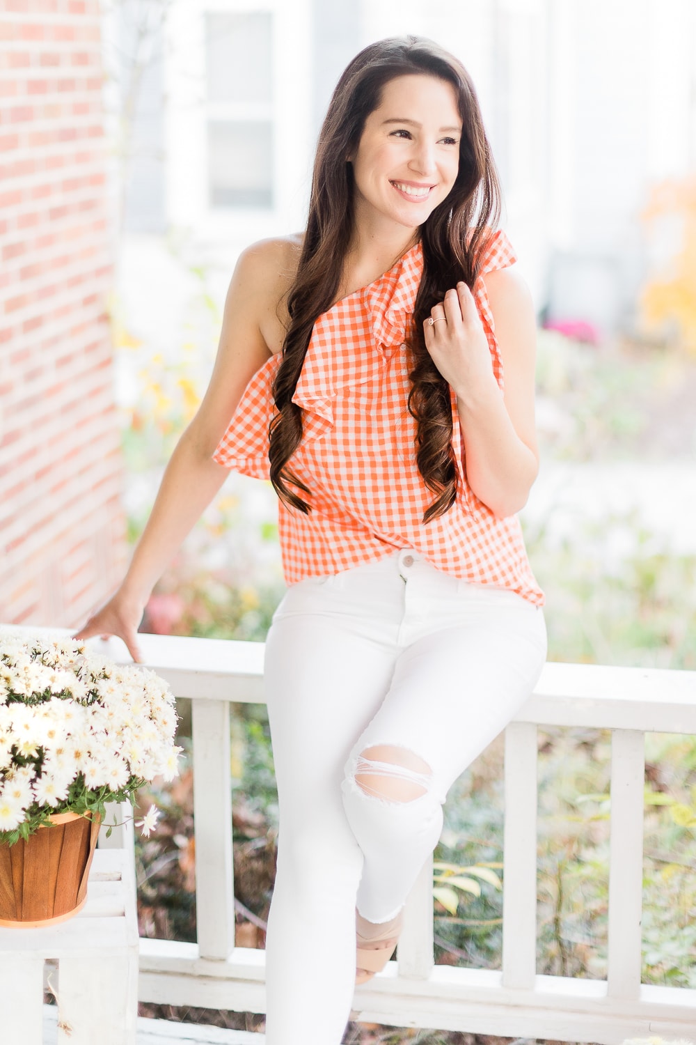 Cute orange ruffle top styled with white skinny jeans by affordable fashion blogger Stephanie Ziajka on Diary of a Debutante