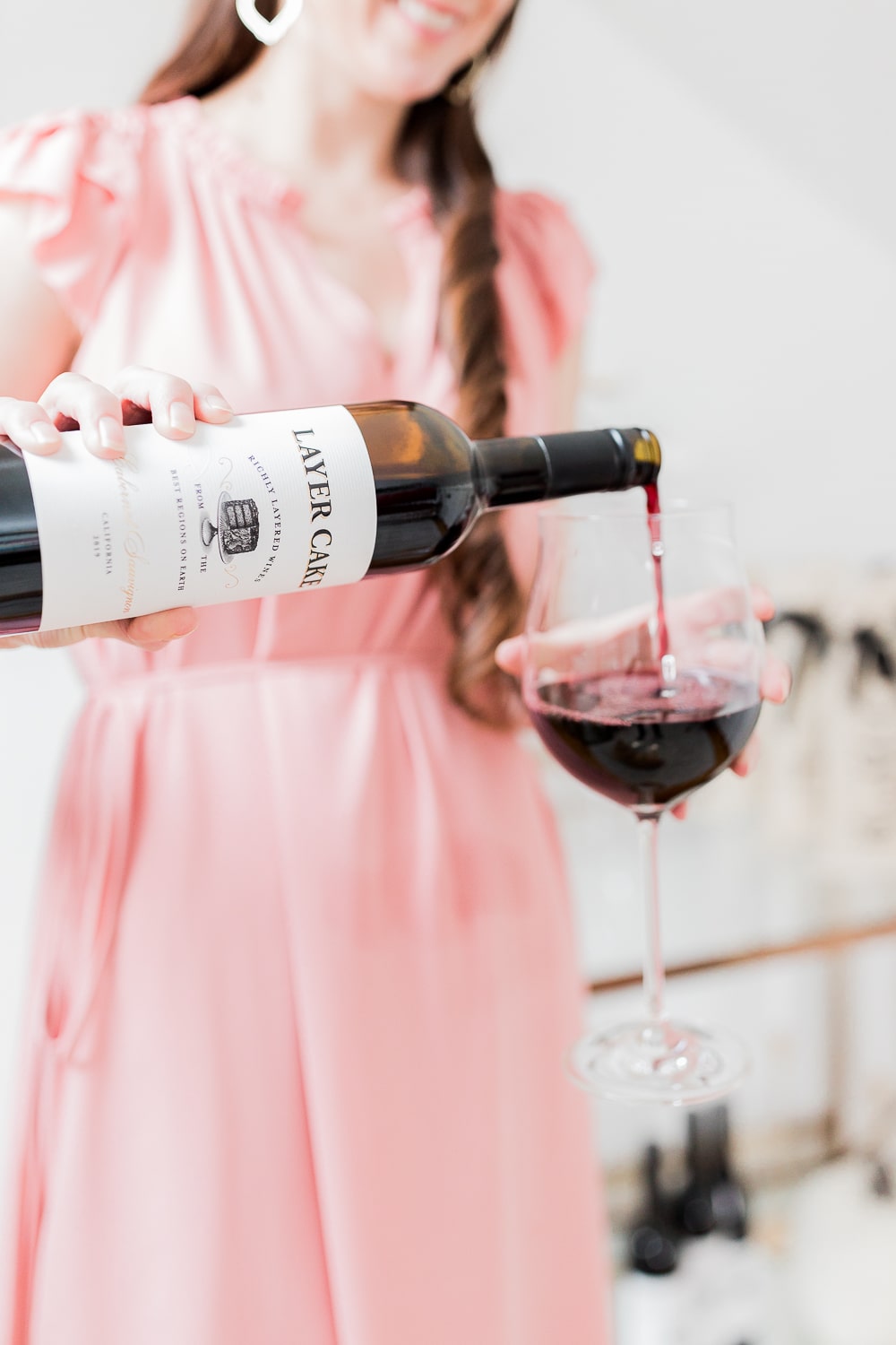 Blogger Stephanie Ziajka pouring red Layer Cake wine on Diary of a Debutante