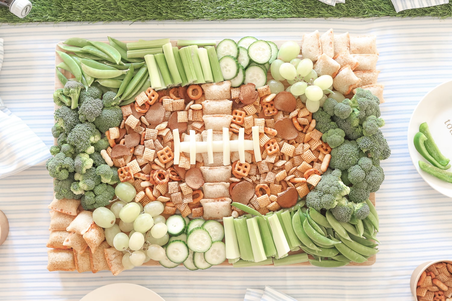 Football snack board created by blogger Stephanie Ziajka using green grapes, green veggies, Chex Mix, and Totino's Pizza Rolls on Diary of a Debutante