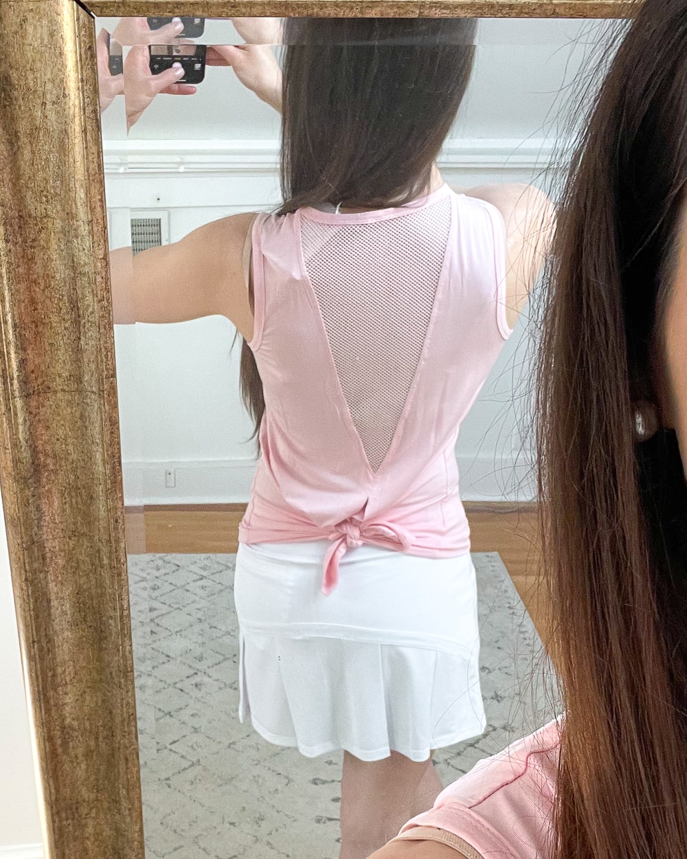 Affordable fashion blogger Stephanie Ziajka shows off the tie back detail of her pink Amazon open back workout tank on Diary of a Debutante