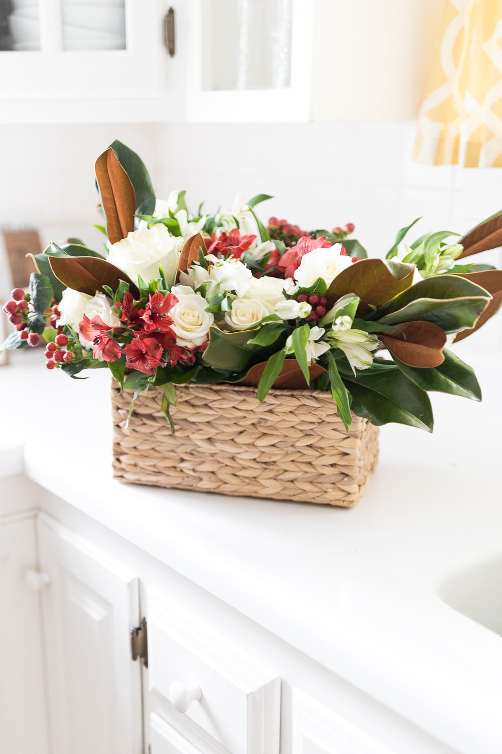 Blogger Stephanie Ziajka shows how to put together a simple Thanksgiving flower centerpiece with magnolia branches, white roses, alstroemeria, and hypericum berries on Diary of a Debutante