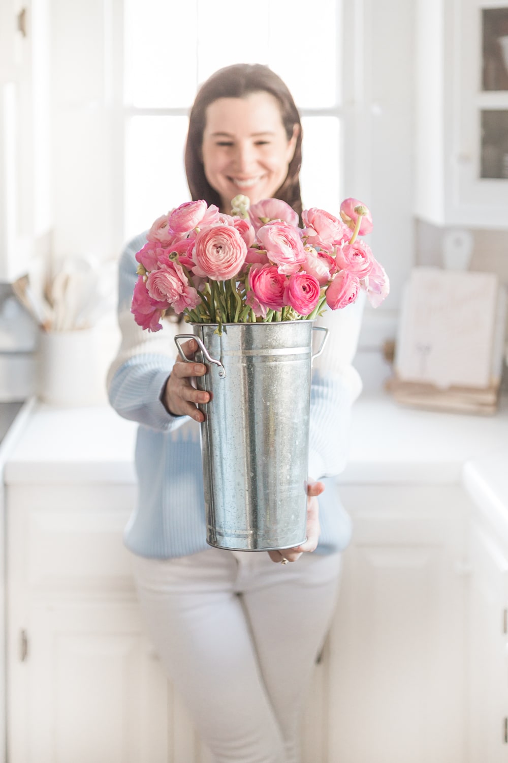 Blogger Stephanie Ziajka holds hot pink ranunculus in a galvanized flower bucket on Diary of a Debutante
