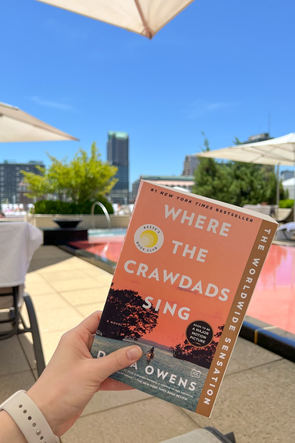 Blogger Stephanie Ziajka reads Where the Crawdads Sing by the Four Seasons St Louis pool on Diary of a Debutante 